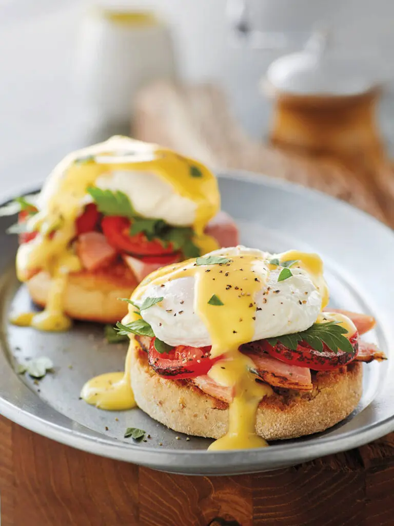 Breakfast meat with eggs Benedict on a plate.